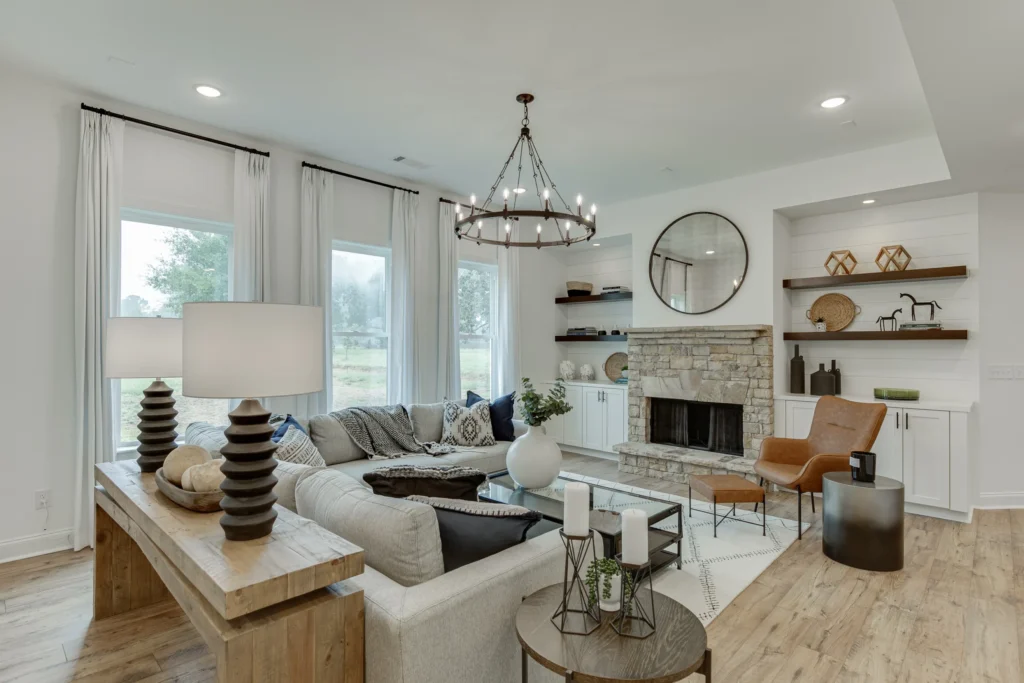 Living area with chandelier, built-in shelving, and floor to ceiling windows